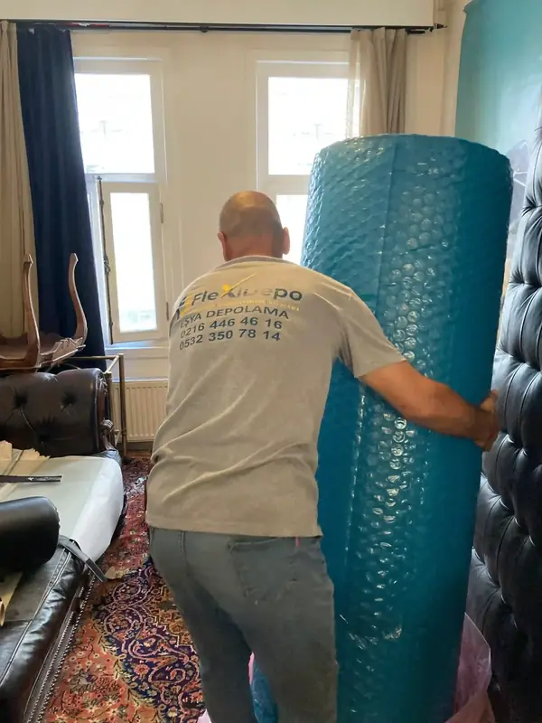 FlexiDepo personeli taşıma öncesi eşyayı balonlu naylonla koruyor